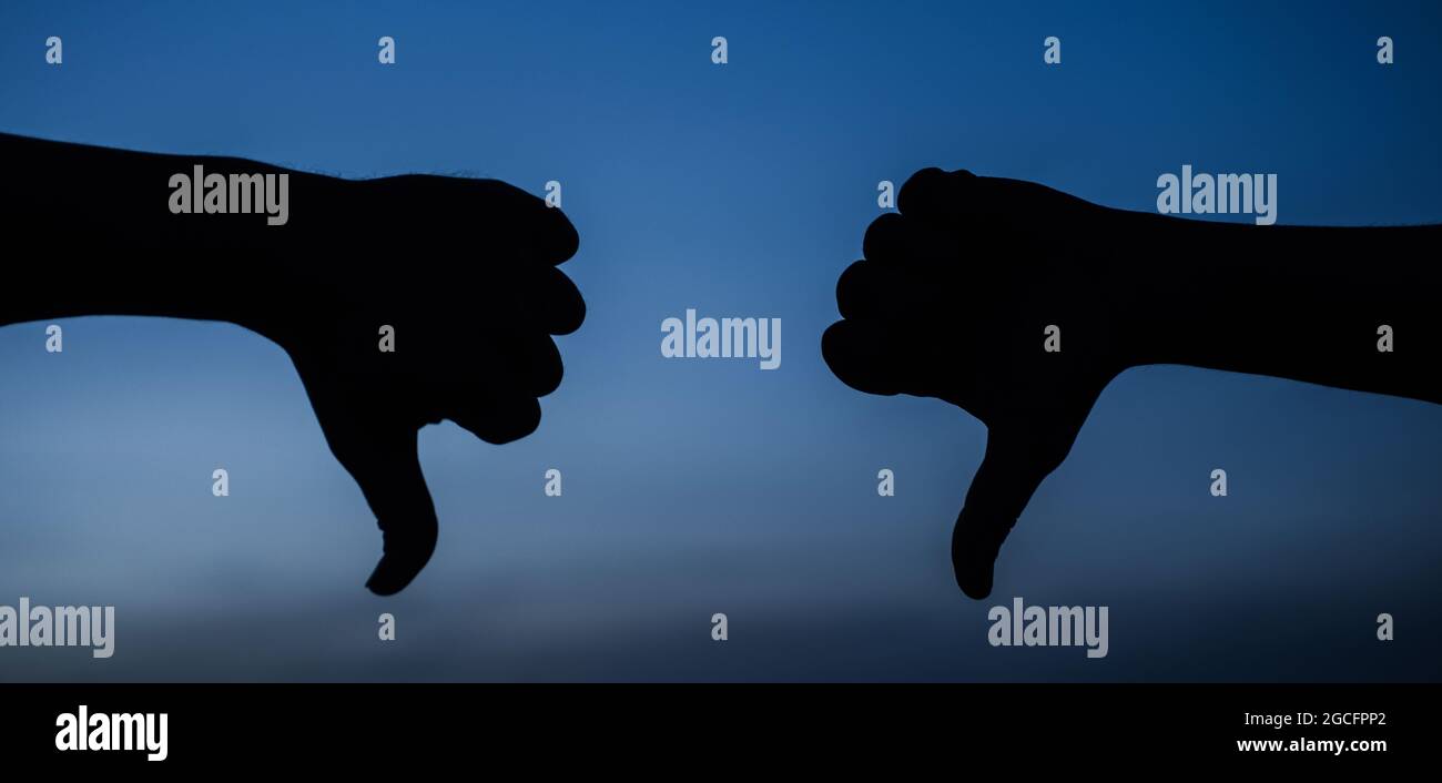 Hands with thumb down gesture. Dislike. Disagree. Rejection symbol. Stock Photo