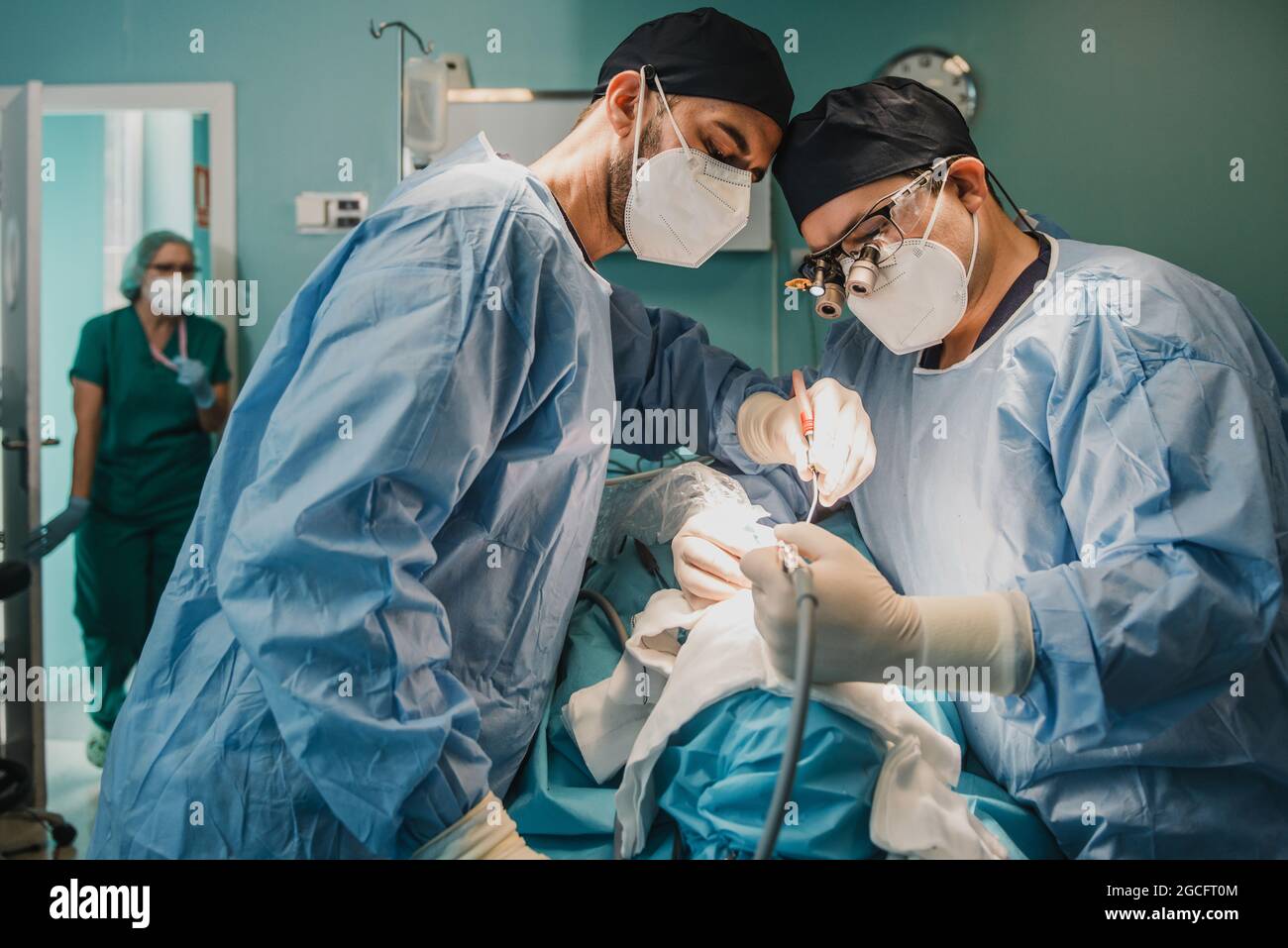 Medical doctors team operating patient in surgical room at hospital - Focus on faces Stock Photo
