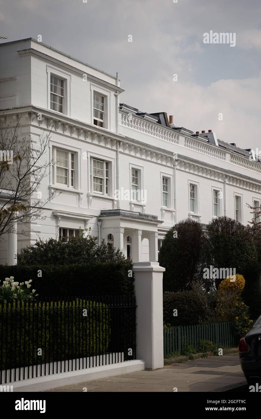 A vertical shot of a beautiful white house with white roses in its ...