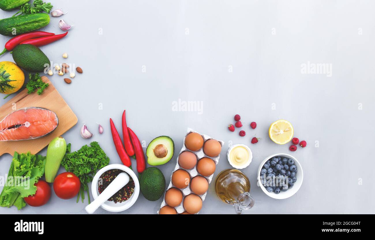 Flat lay with different food, organic vegetables, bio fruits, berries, nuts, spices, herbs, olive oil, chicken eggs and cut of salmon fish. Copy space Stock Photo