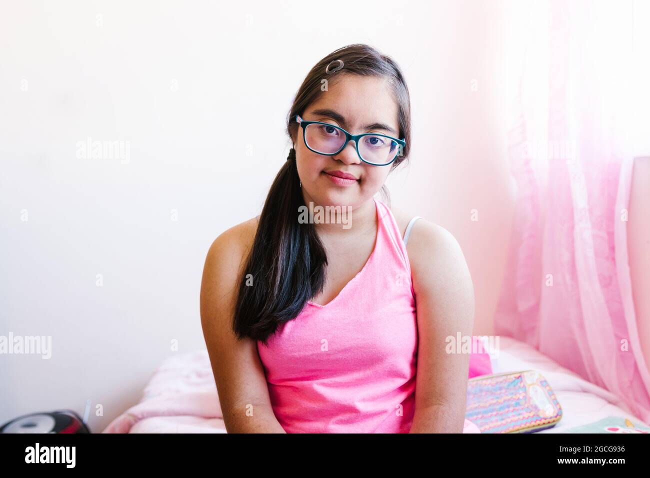 Portrait of latin teen girl with down syndrome in her room, in disability concept in Latin America Stock Photo