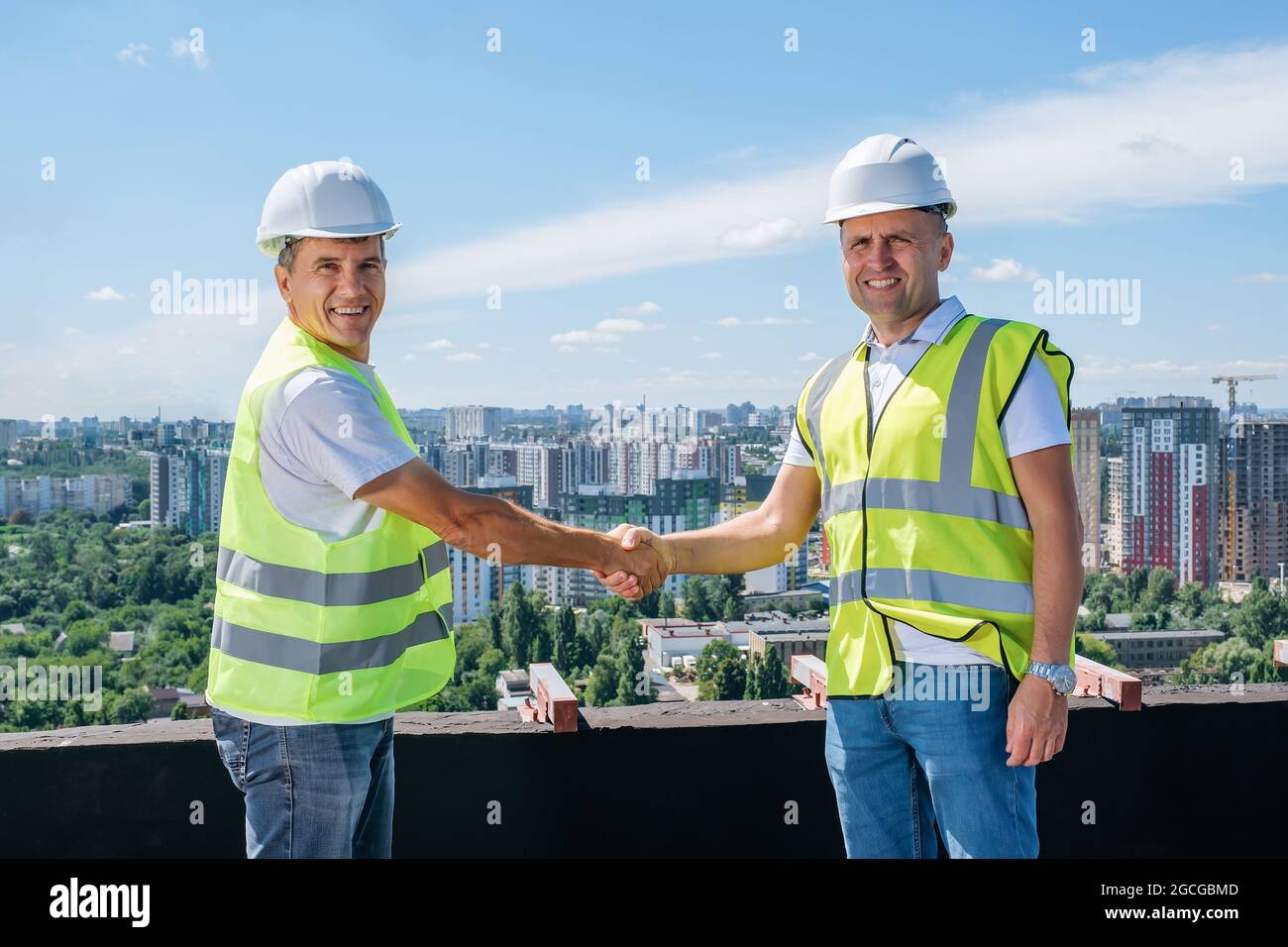 Architect and civil engineer shaking hands on the construction site. Stock Photo