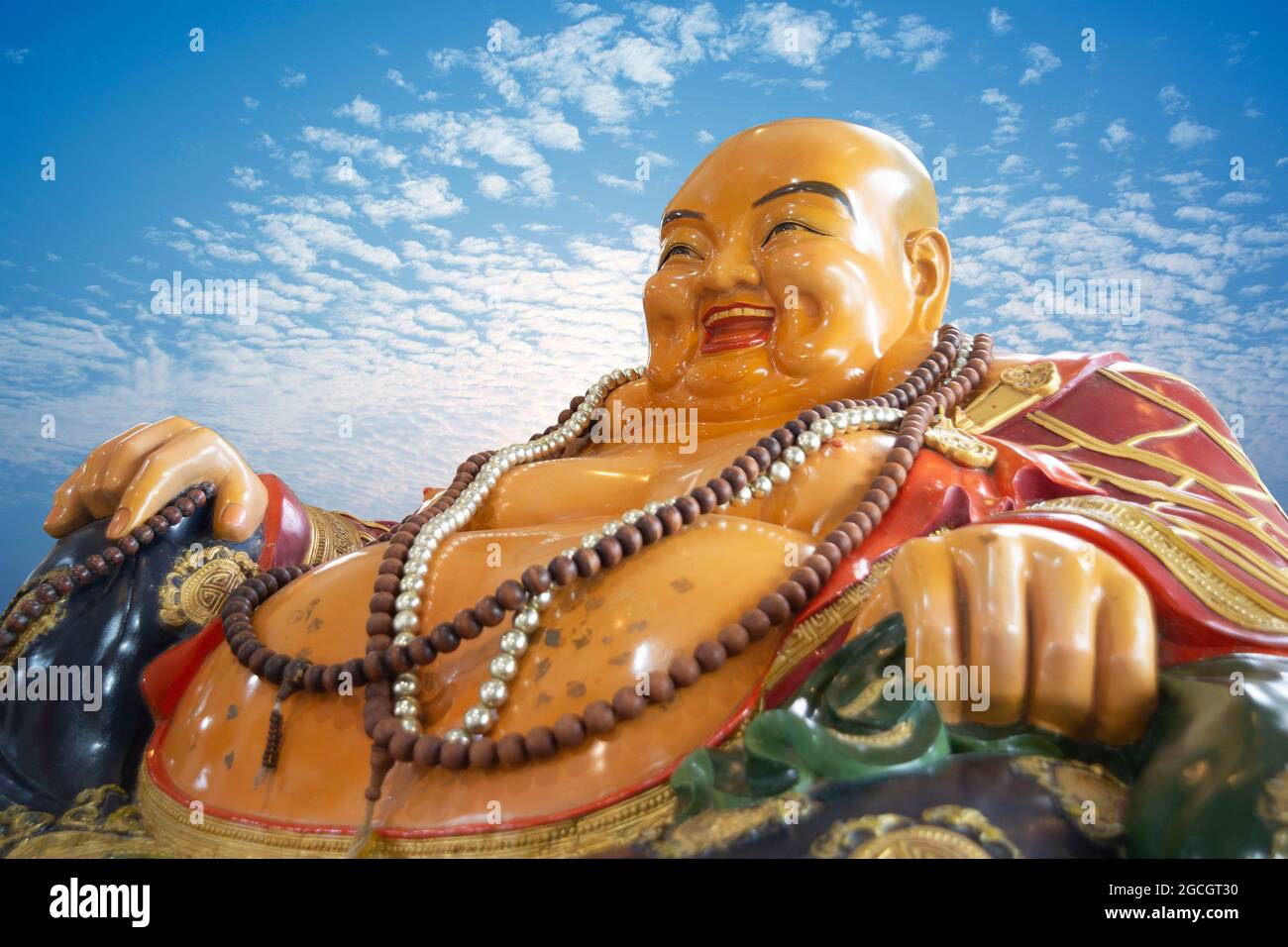 Smiling Buddha, god of happiness, wealth and lucky on blue sky background Stock Photo