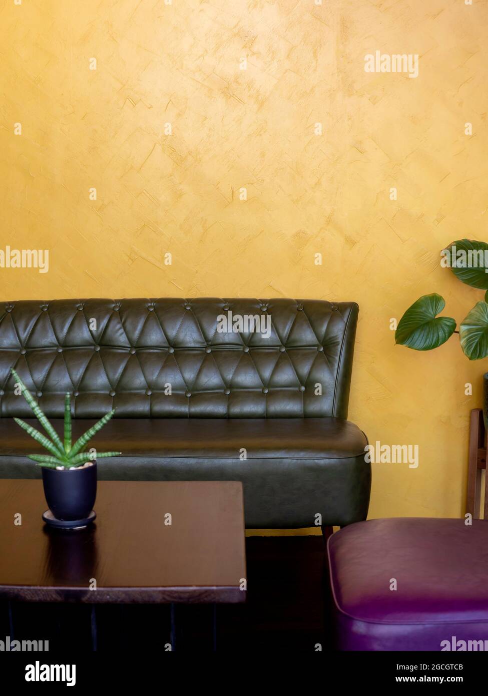 Dark green vintage leather sofa seat with pins and buttons near wooden ...
