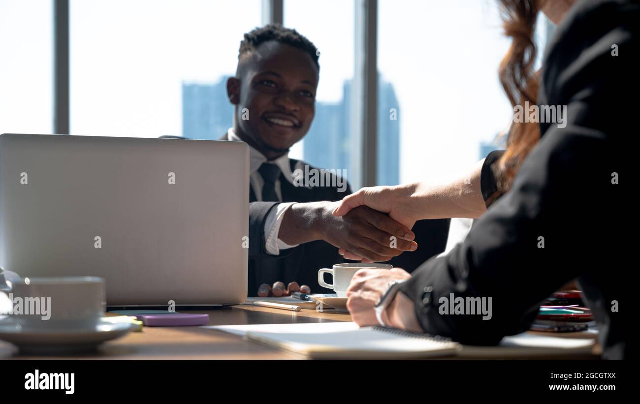 Close up hands shake of African businessman with Caucasian women. Diversity teamwork concept. Stock Photo