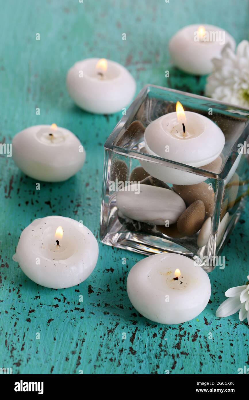 Decorative vase with candles, water and stones on wooden table closeup Stock Photo Alamy