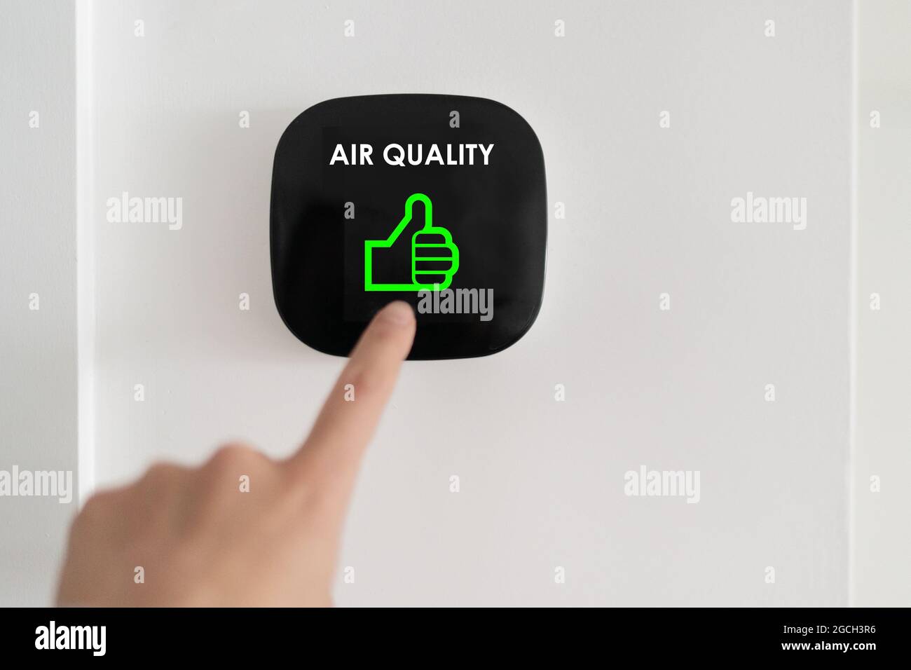 Good air quality indoor smart home domotic touchscreen system. air. Woman touching touchscreen checking air purifier filter at green level with thumbs Stock Photo