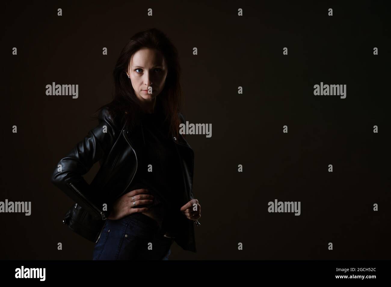 portrait of an attractive young brunette woman in a black leather ...