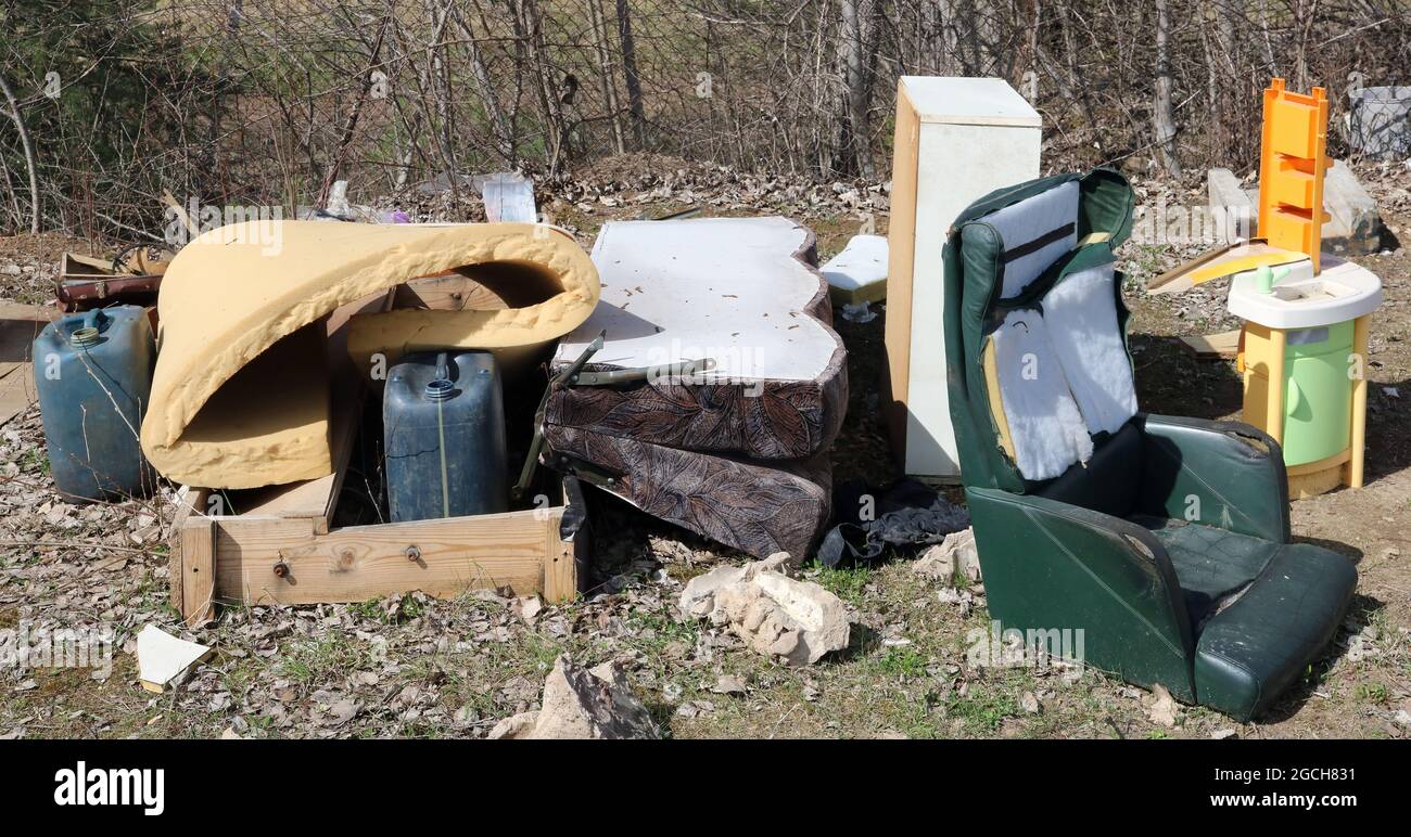Old broken furniture at the garbage dump in soring forest Stock Photo