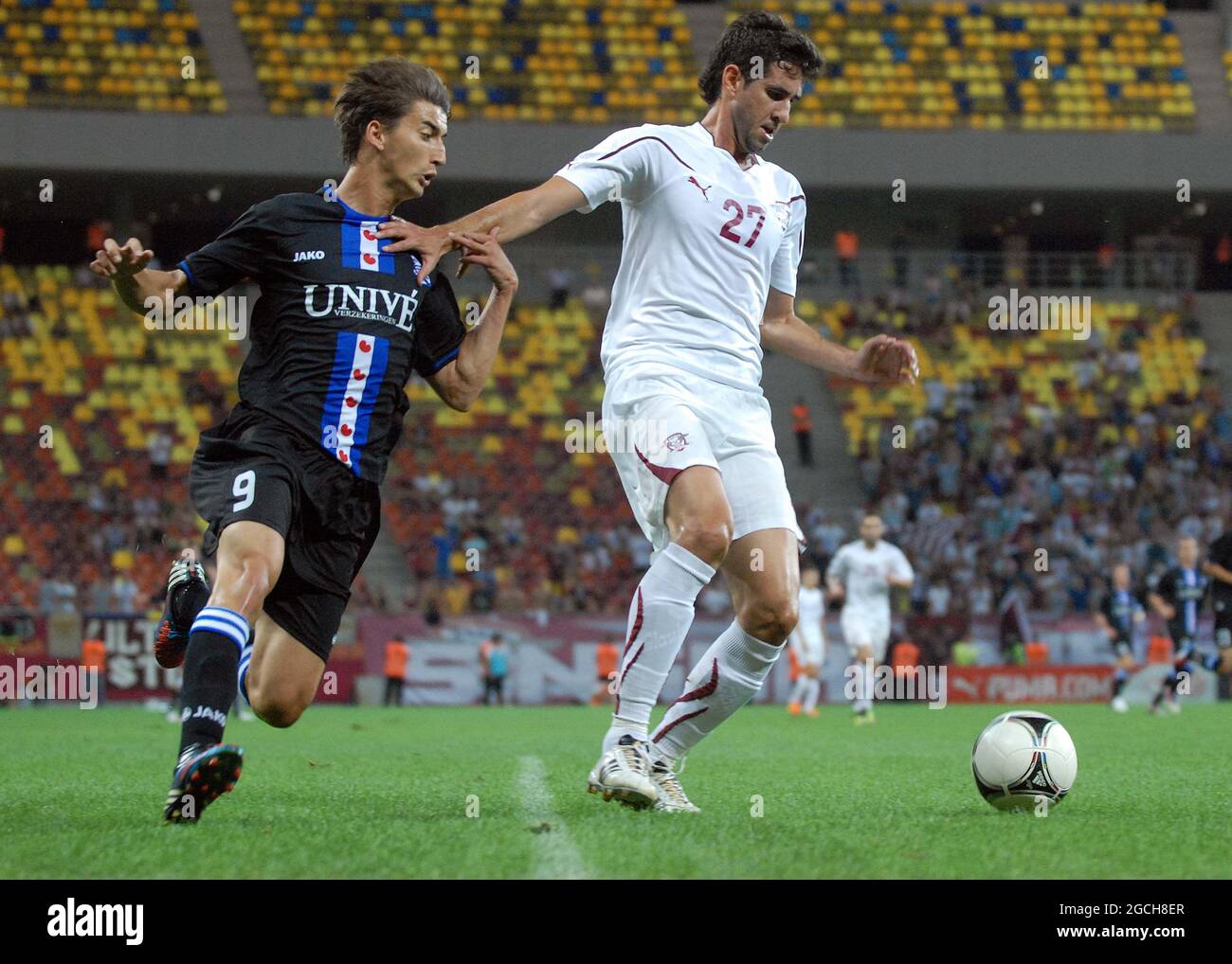 BUCHAREST, ROMANIA - AUGUST 9, 2012: Filip Djuricic (L) of Heerenveen and Glauber (Glauber Leandro Honorato Berti) (R) of Rapid pictured in action during the second leg of the 2012/13 UEFA Europa League Third Qualifying Round game between Rapid Bucuresti and FC Heerenveen at National Arena. Stock Photo