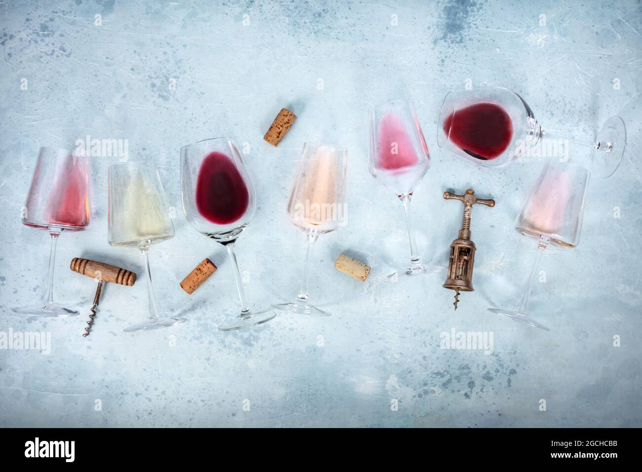 Wine background with glasses of rose, red, and white wine, with corscrews and corks, overhead flat lay shot with copy space. Various colors Stock Photo