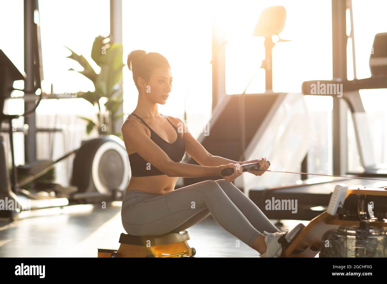 Young woman exercising rowing machine hi-res stock photography and ...