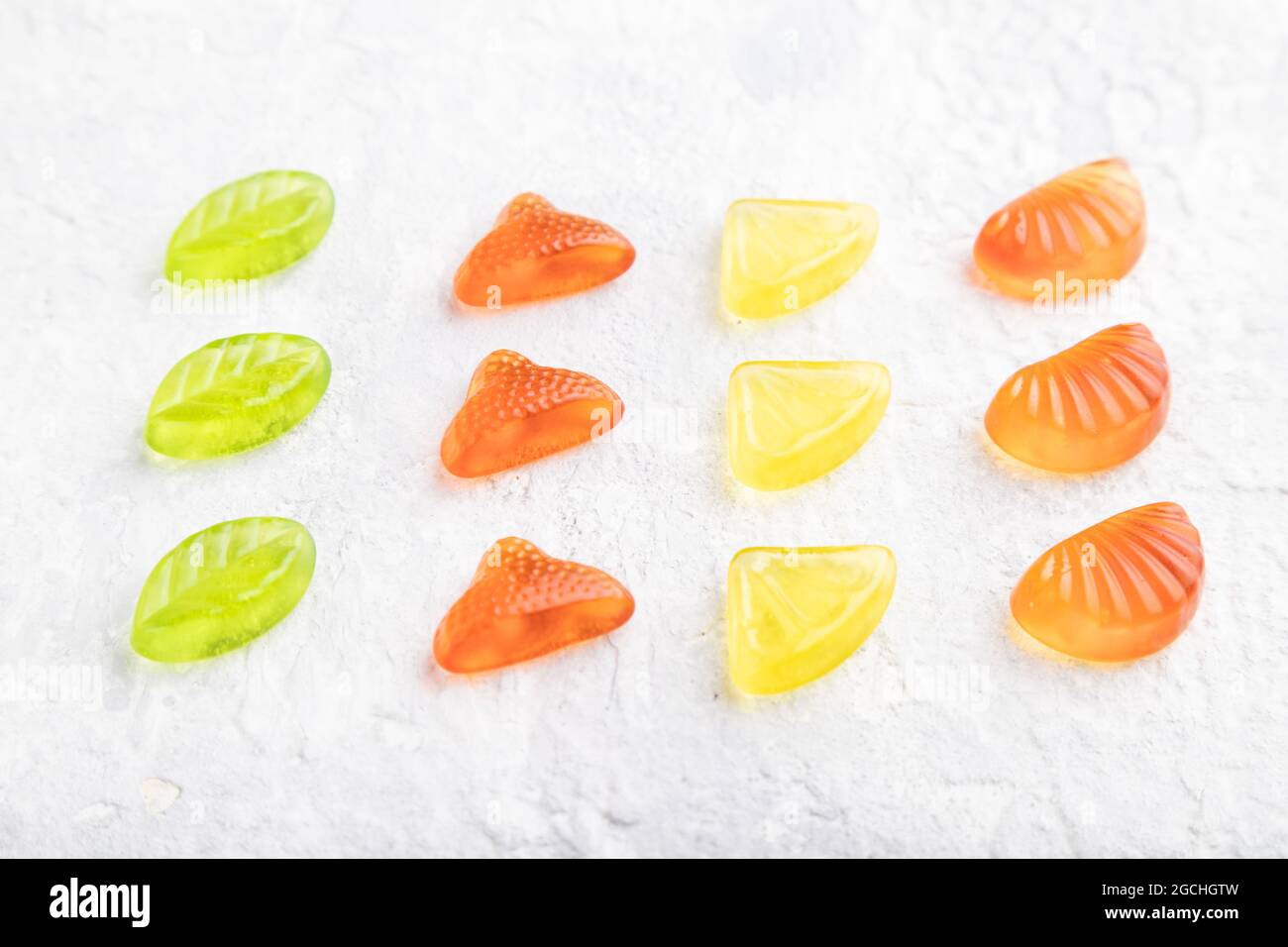Various fruit jelly candies on gray concrete background. side view, close up. Stock Photo