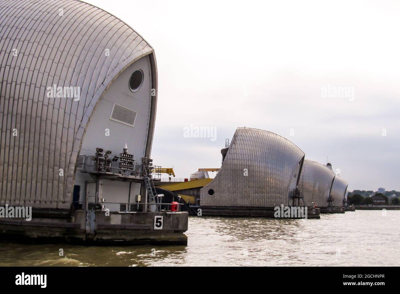 Looking along the line of the Steel-clad shells of the gates of the Thames barrier in the Thames estuary at Silvertown Greater London, UK Stock Photo
