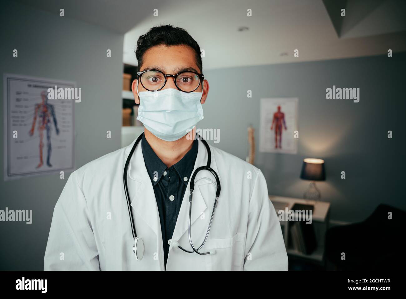 Mixed race professional doctor working in clinic wearing mask Stock Photo