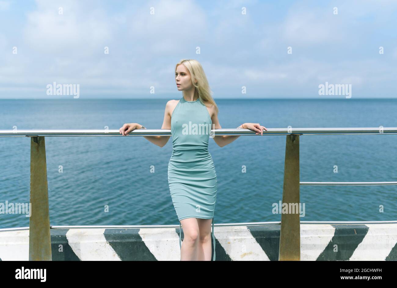 Woman in blue dress enjoys sea on the pier Stock Photo - Alamy