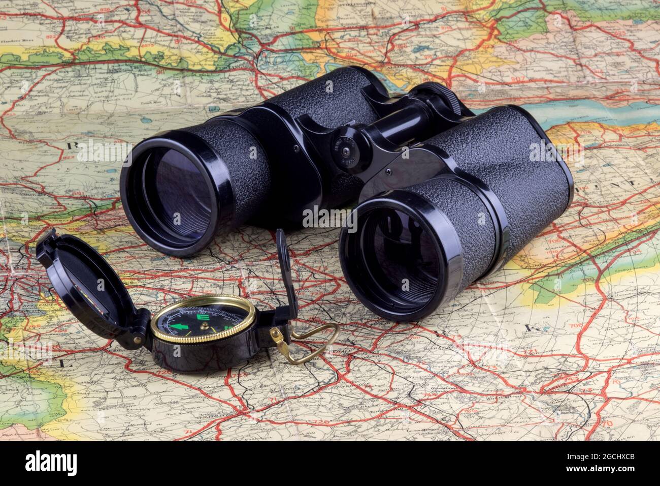 Binoculars and trecking compass on an old route map Stock Photo - Alamy