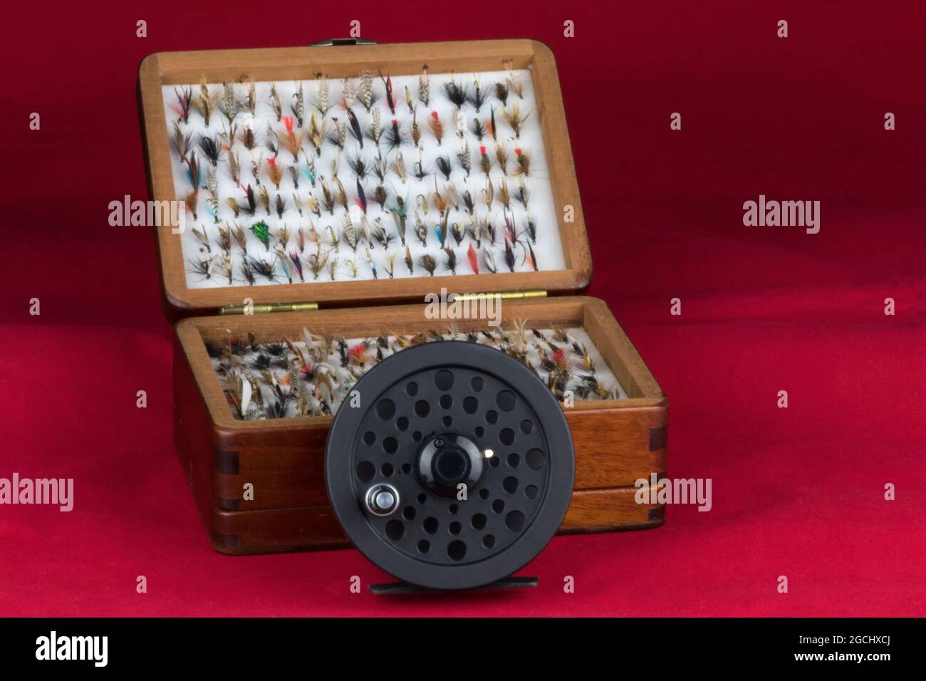 https://c8.alamy.com/comp/2GCHXCJ/fly-fishing-reel-with-flies-and-fly-box-isolated-on-red-2GCHXCJ.jpg