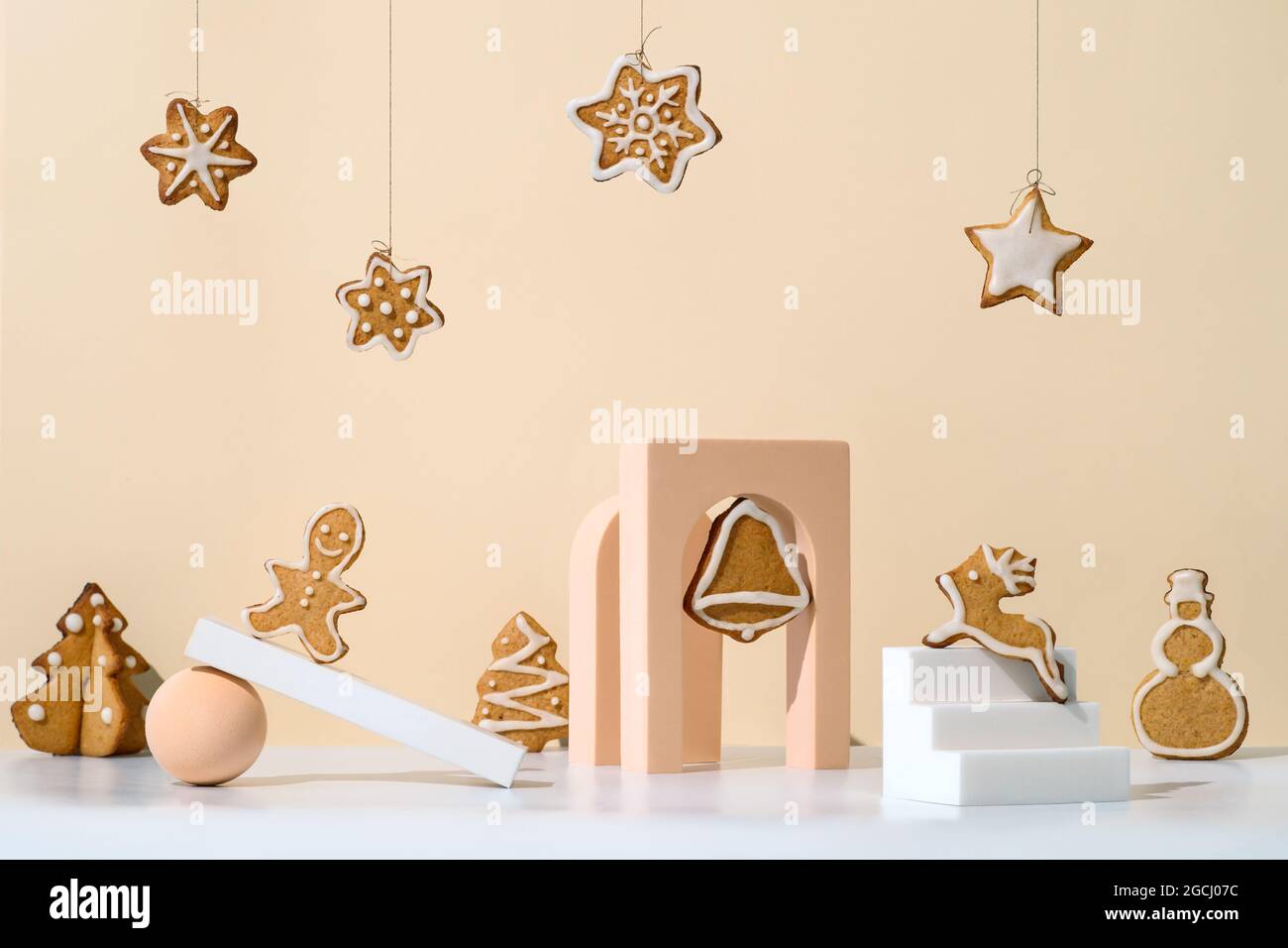 Christmas composition with gingerbread cookies in trendy minimalistic style. Different geometrical shapes, podiums and christmas cookies on neutral cream background Stock Photo