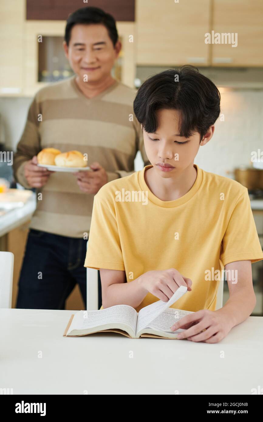 Proud father bringing fresh homemade buns to his teenage son re photo