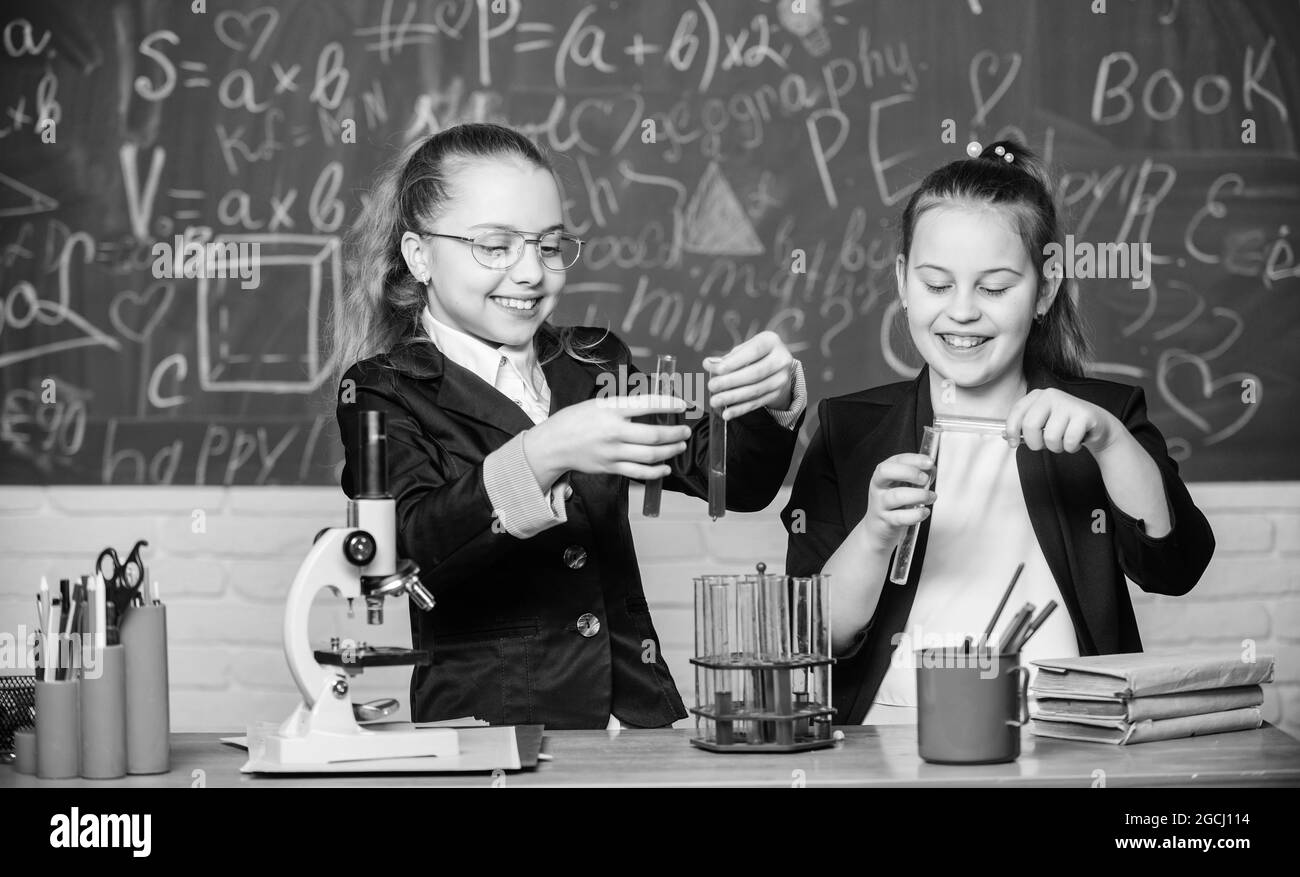 Little girls scientist work with microscope. Little girls in school lab