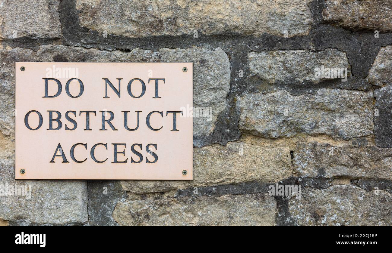 Do Not Obstruct Access sign on stone wall, background banner image Stock Photo