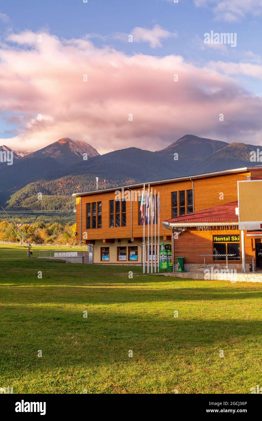 Bansko, Bulgaria - October 31, 2020: Autumn view with gondola lift station and Pirin mountain peaks, pink morning clouds Stock Photo