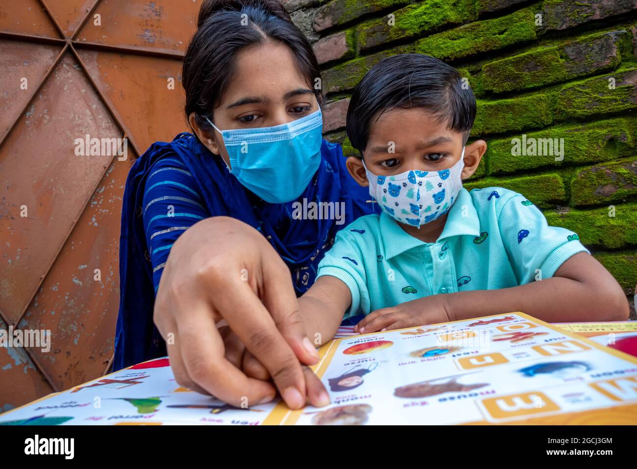 In the lockdown and home quarantine of the Covid-19 epidemic, an Asian  mother is teaching her child at home wearing a mask at Joypara, Dohar,  Dhaka, B Stock Photo - Alamy