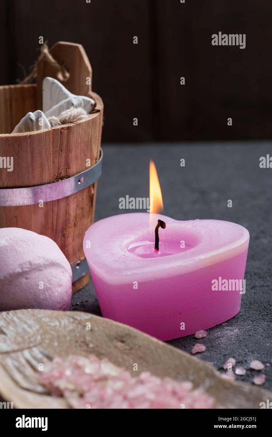 SPA still life, closeup of pink lit candle and bath salt on concrete background Stock Photo