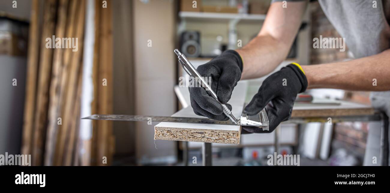 Close up of carpenter holding ruler and pencil while making marks on