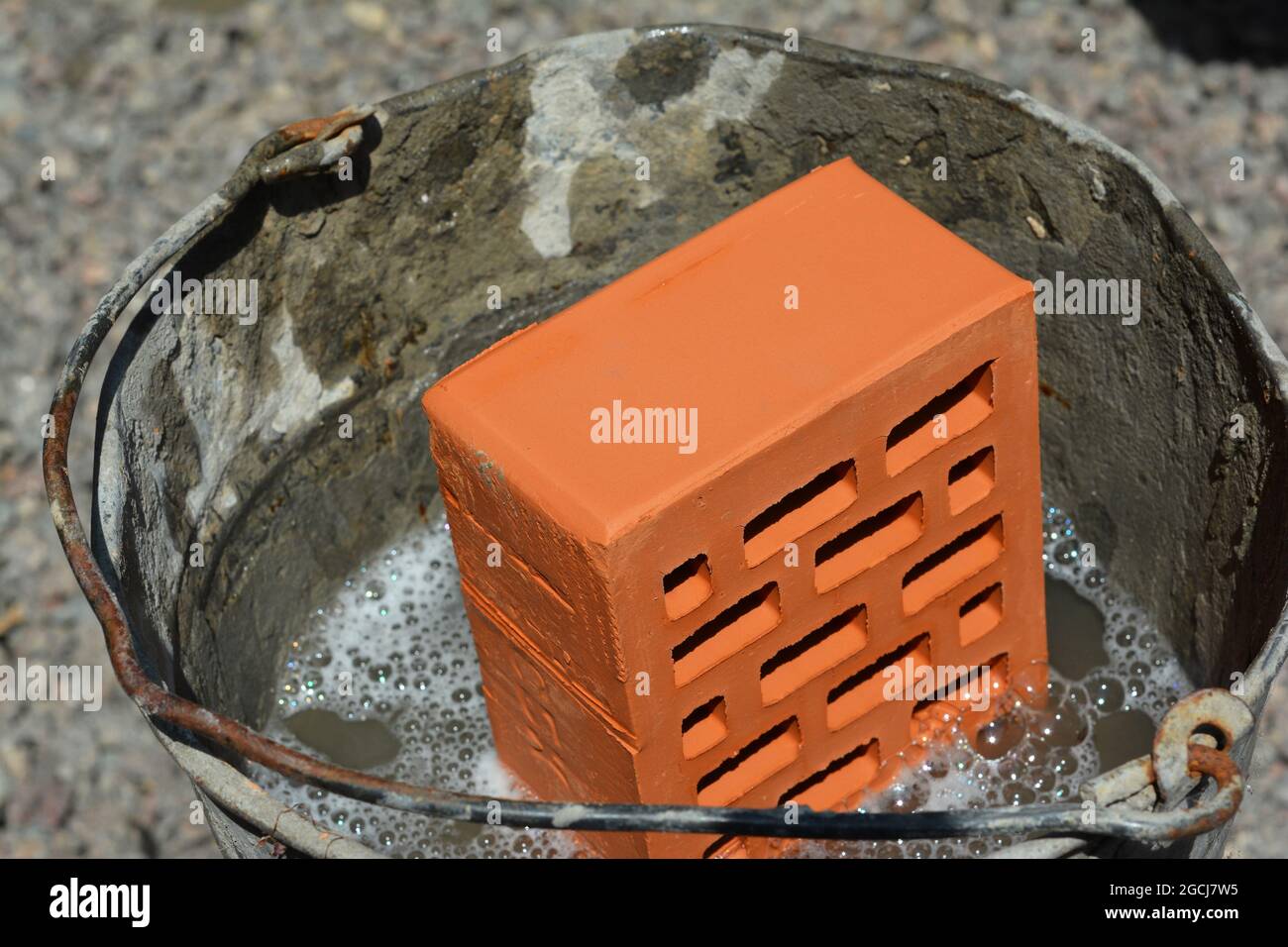 Wetting of bricks, soaking bricks in water before laying the bricks for good mortar strength. Stock Photo
