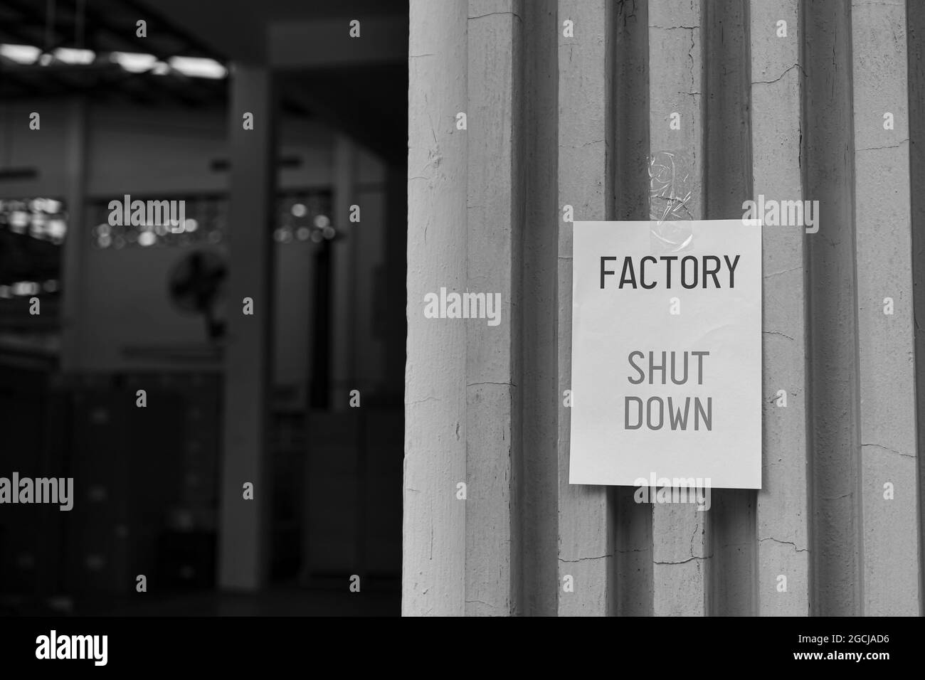 Factory Shut Down sign in front of the factory warehouse. Business shutdown because of economic recession and Coronavirus Covid-19. Stock Photo