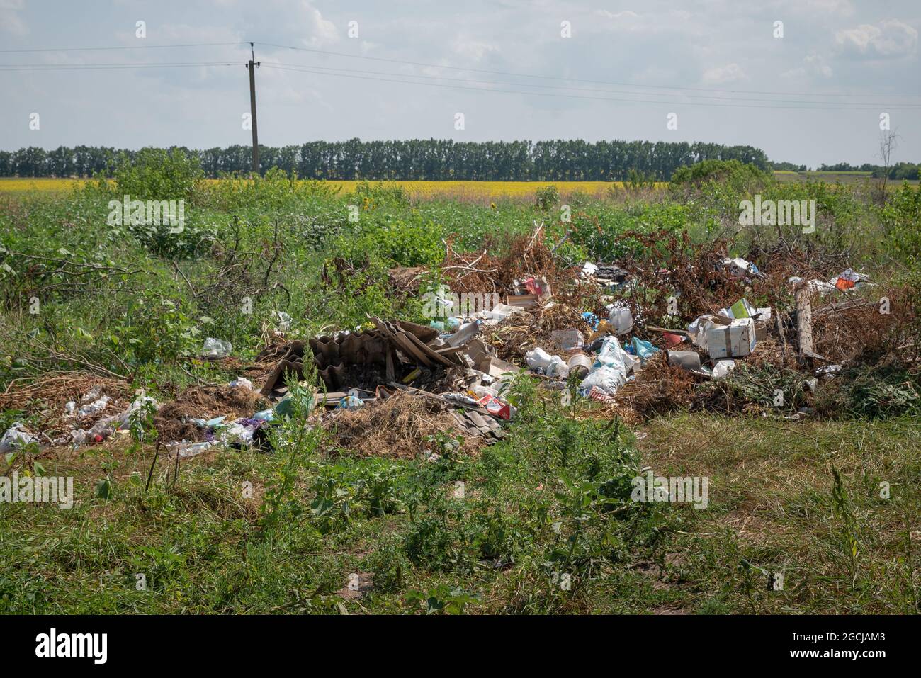 A garbage heap in the middle of the field. Household waste, Illegal