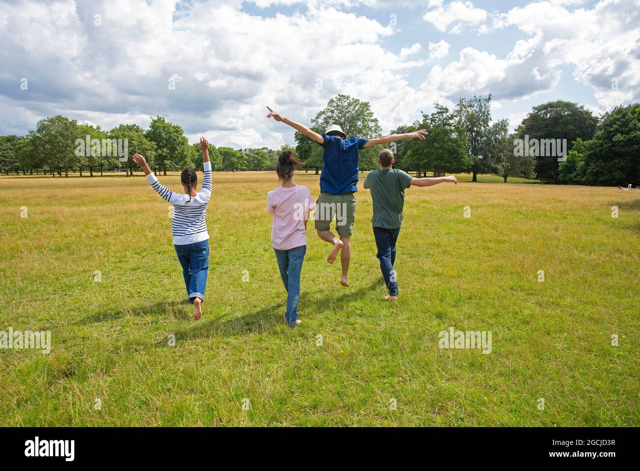 A group of young people are running in the park. Stock Photo