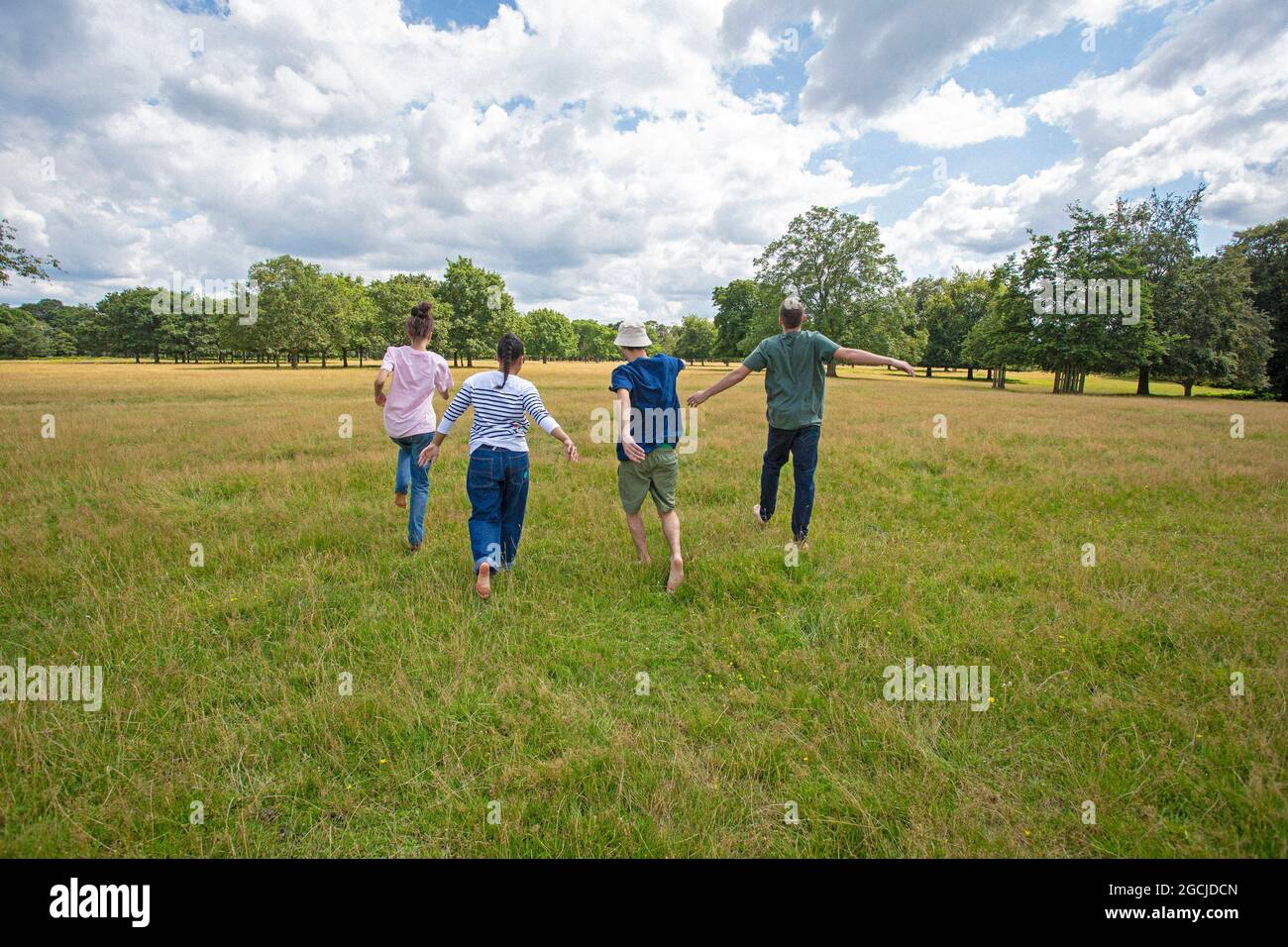 A group of young people are running in the park. Stock Photo