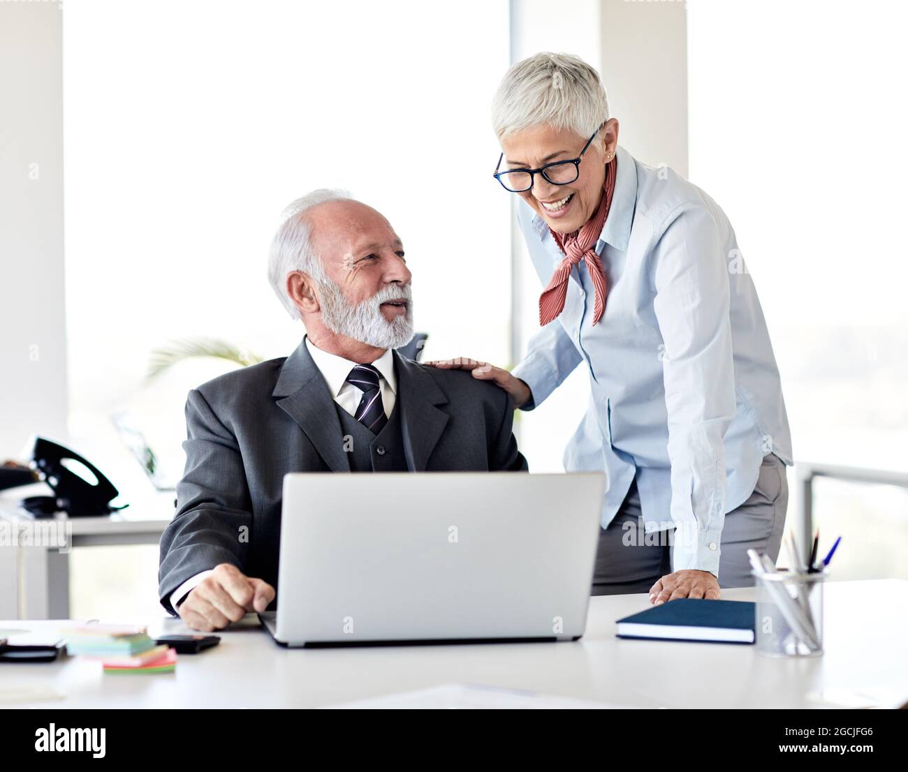 business office person discussion laptop teamwork senior meeting businesswoman businessman together Stock Photo