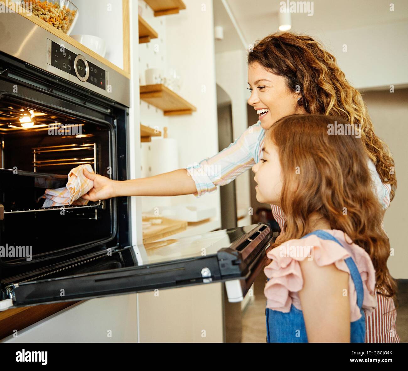 daughter mother kitchen food preparing cooking child oven baking homemade girl home parent Stock Photo