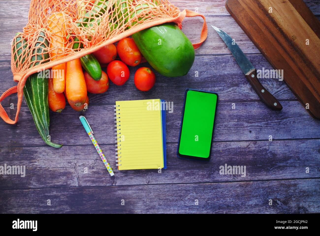 fresh vegetables, cutting board, notepad and smart phone on table Stock ...