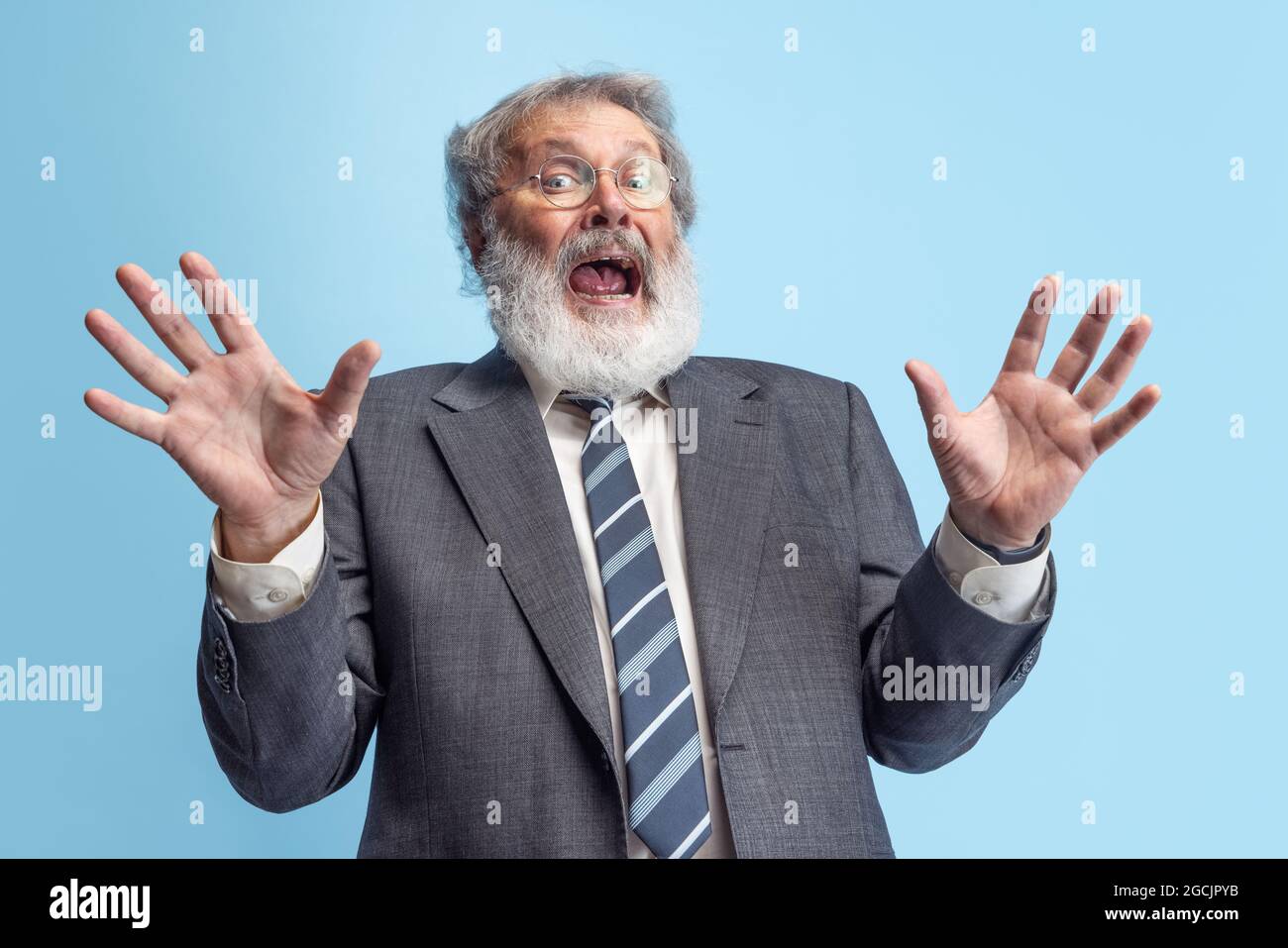 Crazy professor, teacher, gray-headed bearded man posing isolated on gray studio background. Concept of professional occupation, job, education, funny Stock Photo