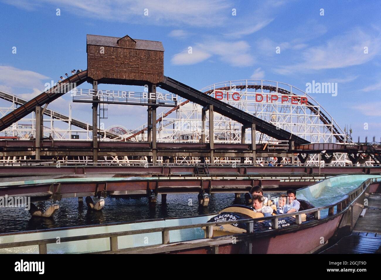 The log flume with the big dipper in the background, Blackpool Pleasure Beach, Lancashire, England, UK. Circa 1980's Stock Photo