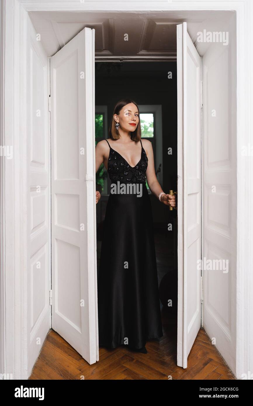 Beautiful woman model dressed in an elegant long black dress in a ...