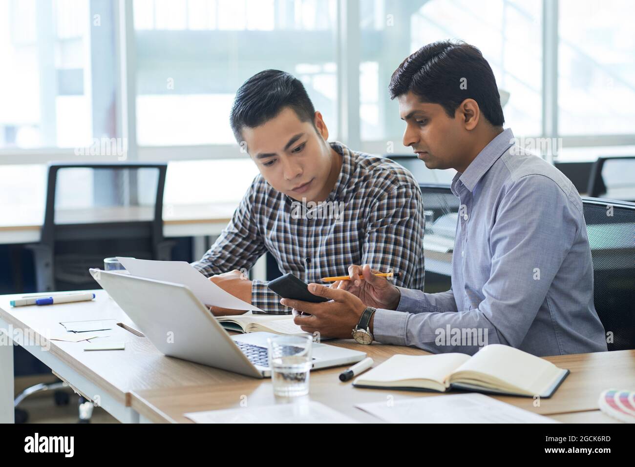 Project manager and UX designer checking work of new interface when using application on smartphone Stock Photo