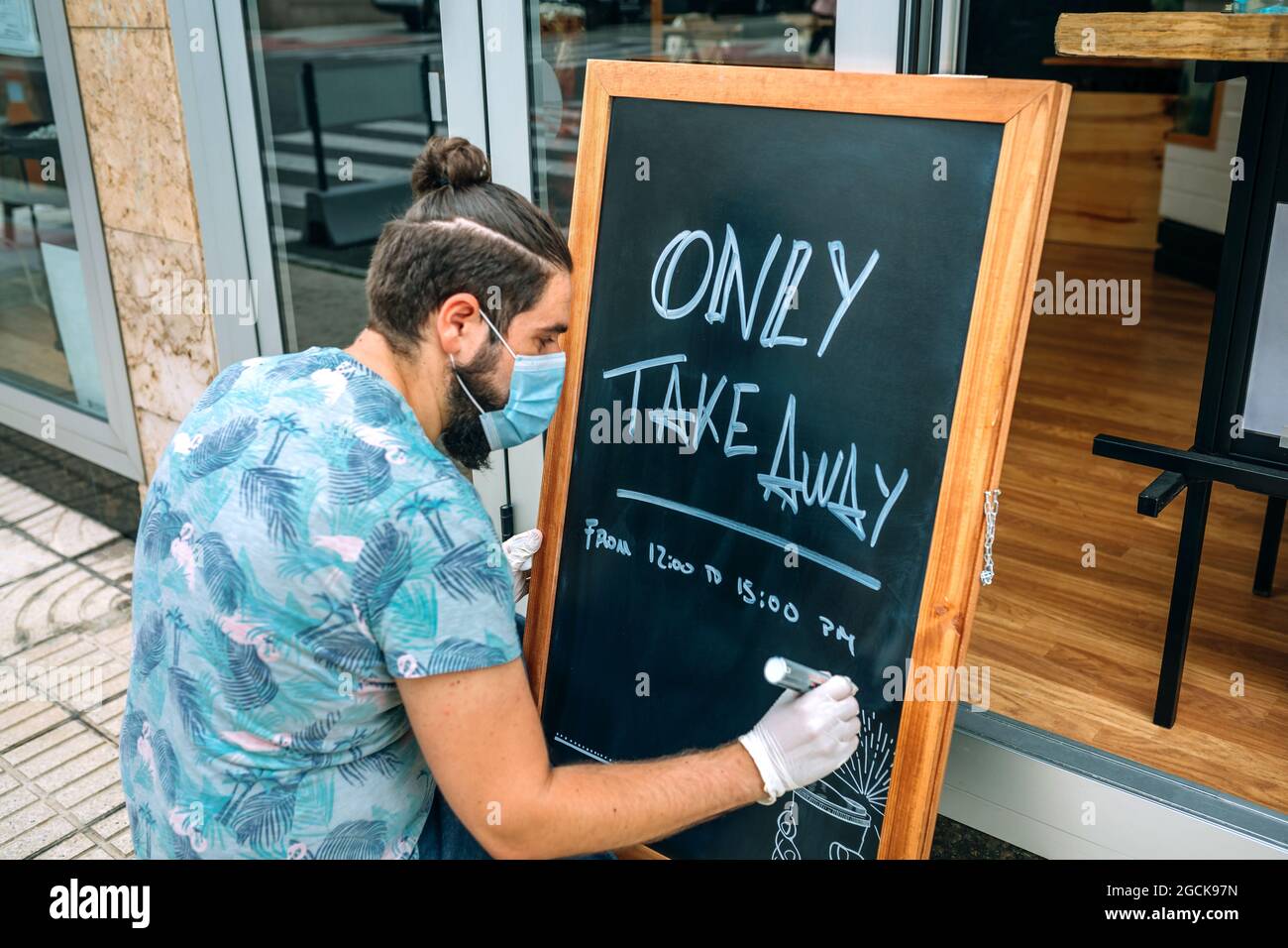Restaurant owner writing on a blackboard Stock Photo