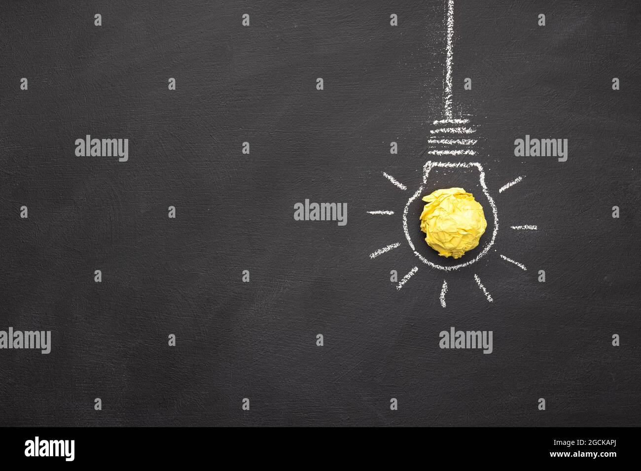 Hand Drawn Light Bulb On blackboard with Copy space. Bright Idea or Creative process concept. Top view Stock Photo