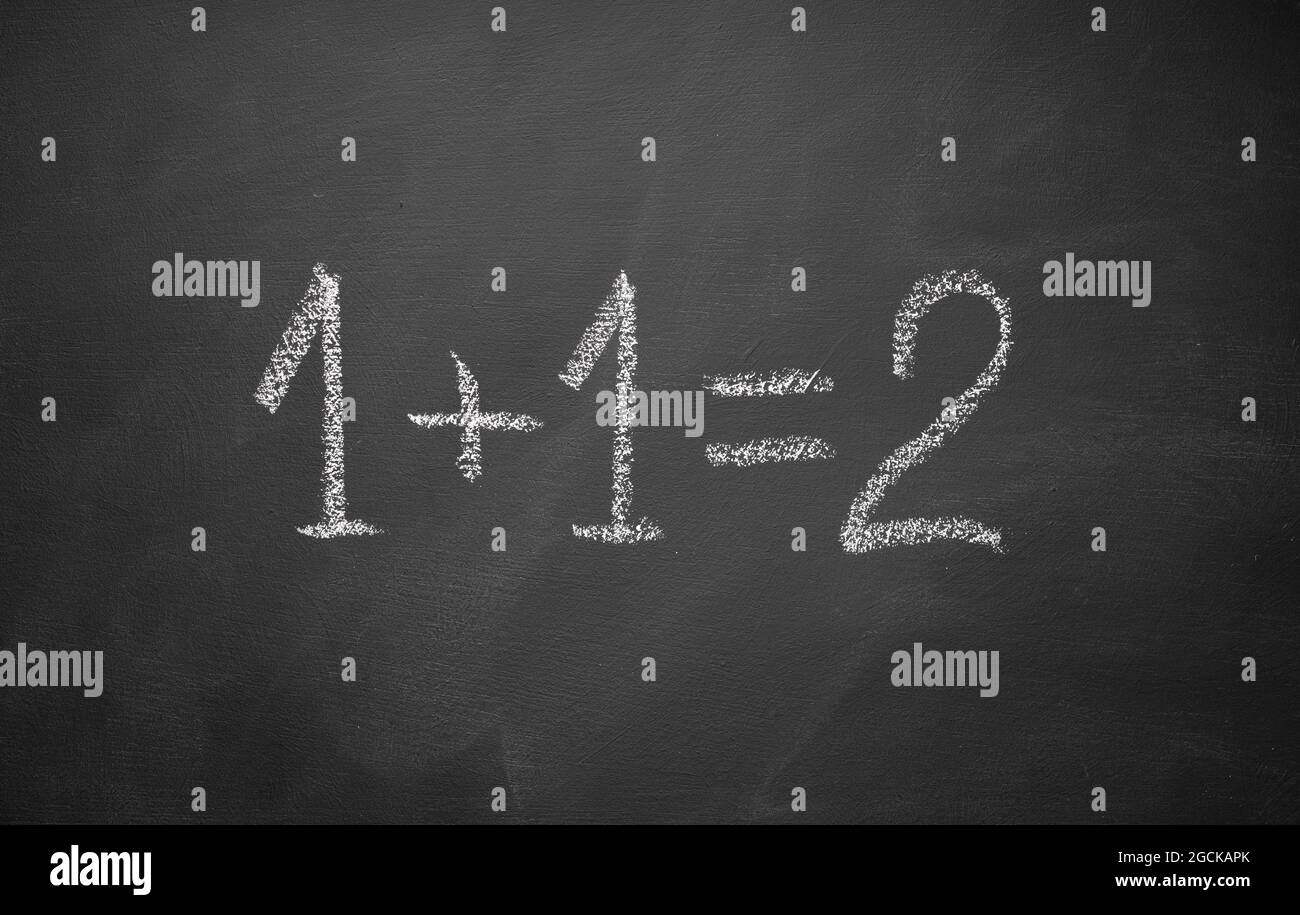 One plus one equals two hand written on chalkboard. Math simple