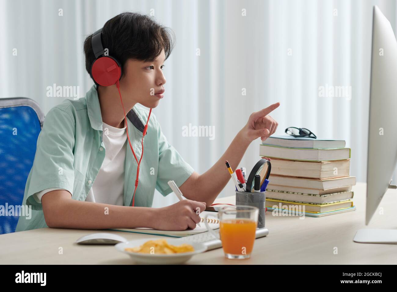 Concentrated schoolboy in headphones watching educational video on