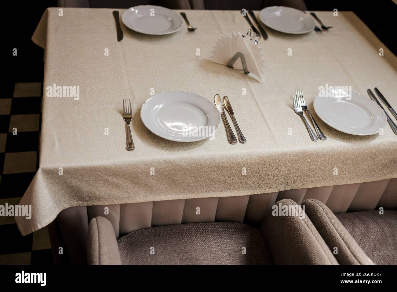 White plate, cutlery and napkin on table. knife and fork on napkin. Top ...