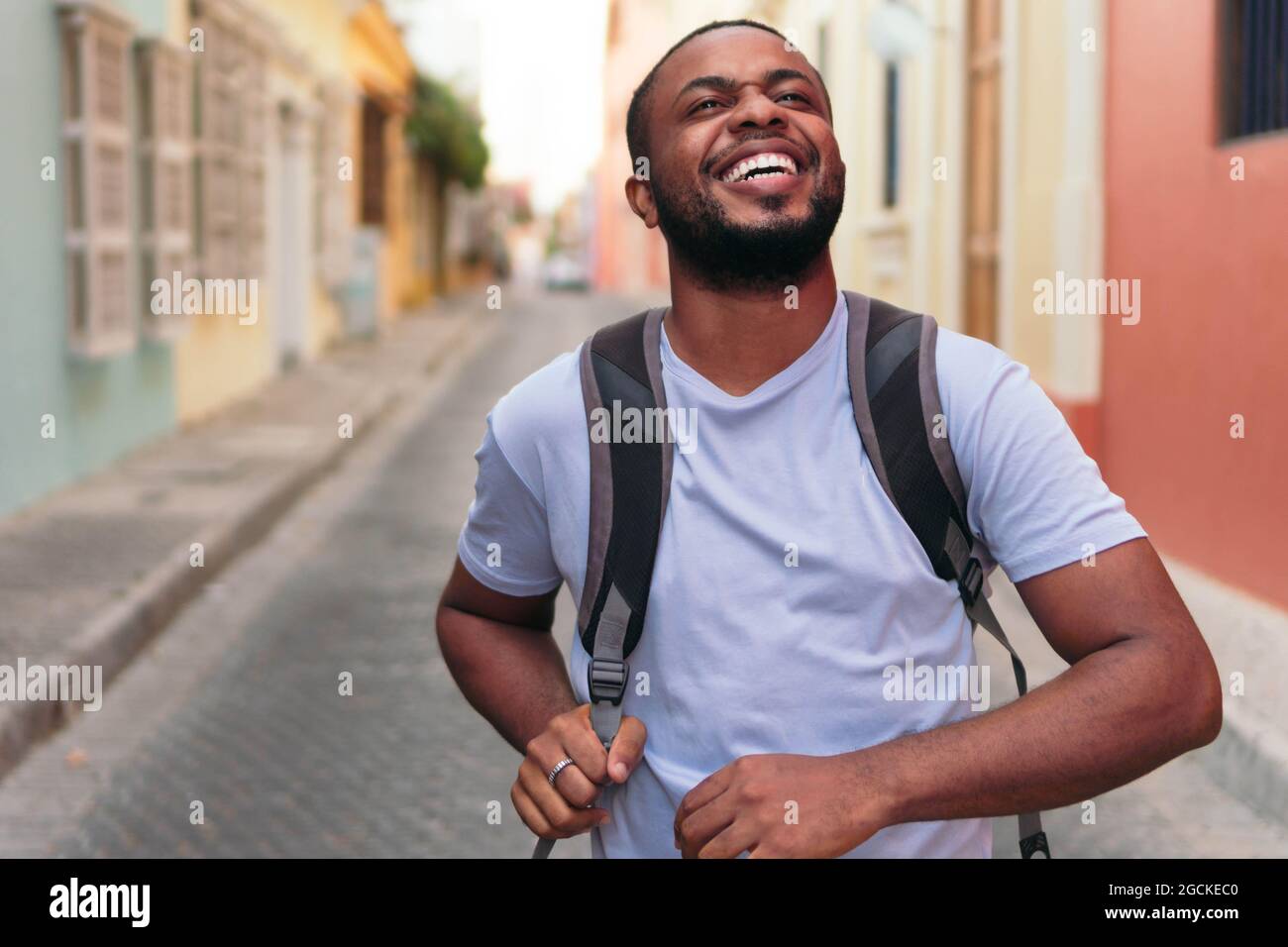 Young African American man carrying backpack while standing outdoors Stock Photo