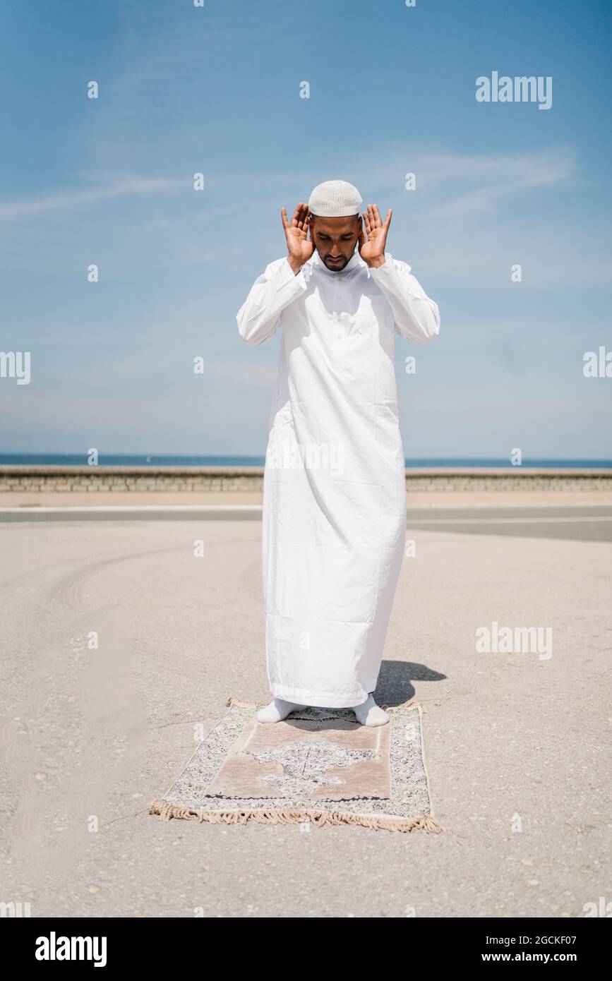 Full Boy Islamic Male In Traditional White Clothes Standing On Rug And full-boy-islamic-male-in-traditional-white-clothes-standing-on-rug-and