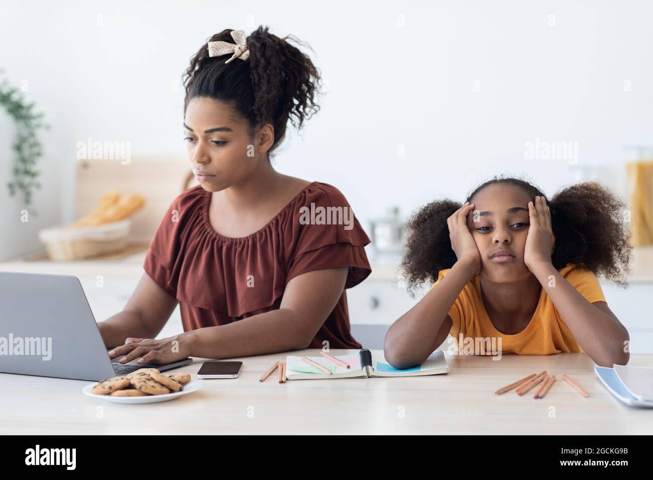Black woman freelancer typing on laptop, working from home, bored ...